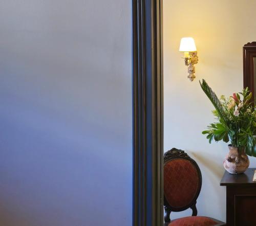 a room with a chair and a vase of flowers at BE Jardin Escondido By Coppola in Buenos Aires
