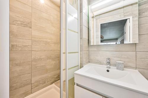 une salle de bain avec un lavabo et un miroir dans l'établissement L'Oasis Parisien - 2 pers - Métro Oberkampf, à Paris