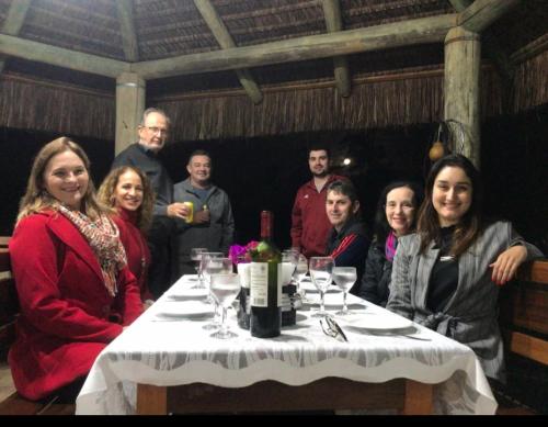 a group of people sitting around a table with wine glasses at Sítio Paz e Sossego in Têsto Salto