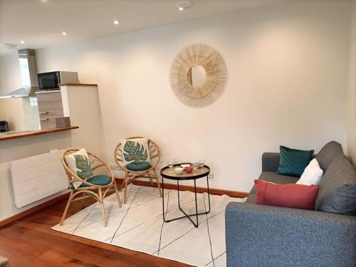 a living room with a couch and chairs and a table at Maison de ville CDG, Villepinte in Juilly