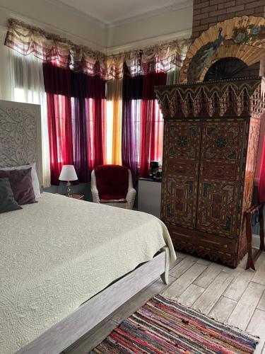 una camera con un grande letto e tende rosse di 1912 Bed and Breakfast a Sumter