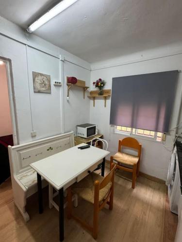 Habitación con mesa, 2 sillas, mesa y ventana. en Apartamento,Albares de la Ribera en Madrid