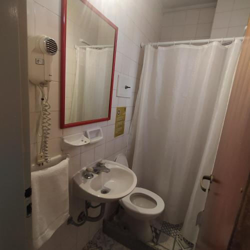 a bathroom with a sink and a toilet and a mirror at Play Hostel Arcos in Buenos Aires