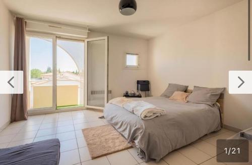 um quarto com uma cama e uma grande janela em Montpellier : Jolie studio très calme em Montpellier
