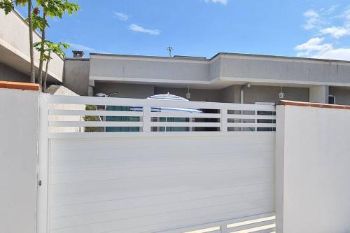 a white garage gate in front of a house at Casa a poucos metros da praia! in Guaratuba