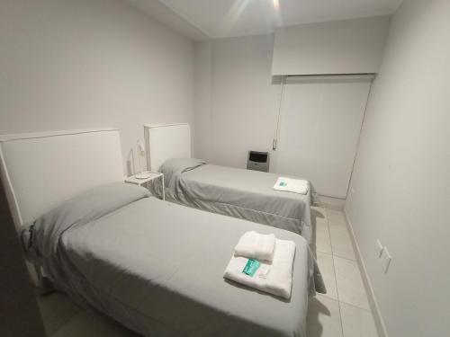two beds in a small room with white walls at Excelente departamento diario en Libertador San Martin, Entre Rios in Libertador San Martín