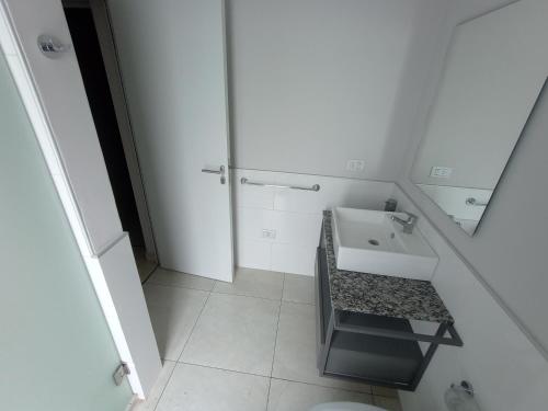 a white bathroom with a sink and a mirror at Excelente departamento diario en Libertador San Martin, Entre Rios in Libertador San Martín