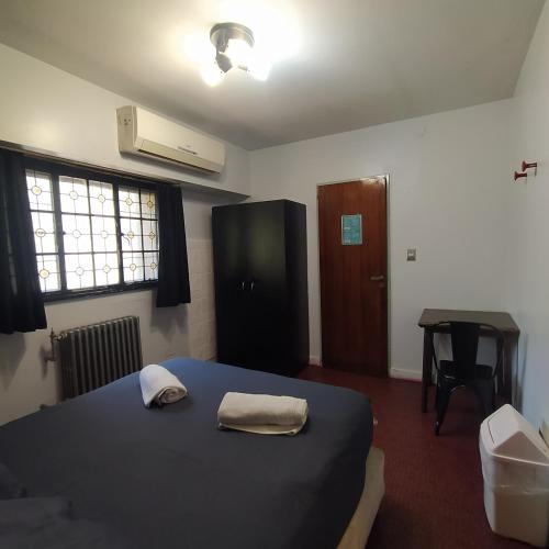 a bedroom with a bed and a desk and a window at Play Hostel Arcos in Buenos Aires
