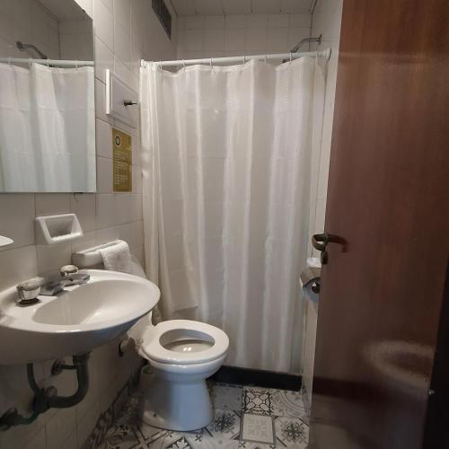 a bathroom with a white toilet and a sink at Play Hostel Arcos in Buenos Aires