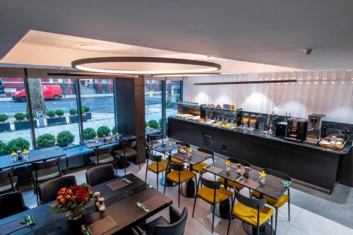 a restaurant with tables and chairs and a bar at voco London Marylebone by IHG in London