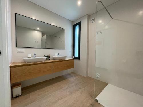 a bathroom with two sinks and a large mirror at Villa Pampelonne in São Martinho do Porto