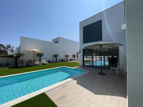 a villa with a swimming pool and a house at Villa Pampelonne in São Martinho do Porto