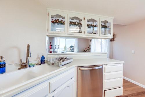 a kitchen with white cabinets and a window at Pismo Beach Condo with Balcony Near Wineries! in Pismo Beach