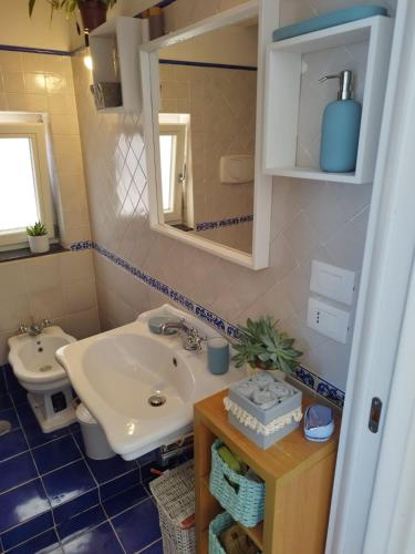 a bathroom with a sink and a toilet and a mirror at Casa Mamma Mia in Albori