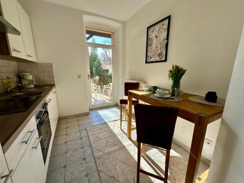 a kitchen with a wooden table and a dining room at Retreat am Teich in Altenburg