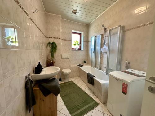 La salle de bains est pourvue d'un lavabo, d'une baignoire et de toilettes. dans l'établissement Retreat am Teich, à Altenburg