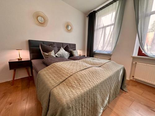 a bedroom with a bed and two windows at Retreat am Teich in Altenburg