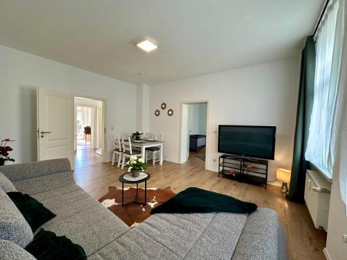 a living room with a couch and a flat screen tv at Retreat am Teich in Altenburg
