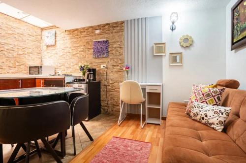 sala de estar con sofá y cocina en Confortable Apto en Normandia, en Bogotá