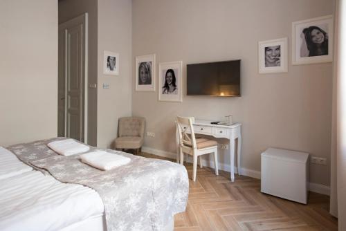 ブダペストにあるSerenity Boutique Budapestのベッドルーム1室(ベッド1台、デスク、テレビ付)