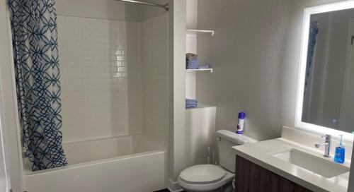 a bathroom with a tub and a toilet and a sink at Glendale Charm: Stylish 1 Bedroom Retreat for Your Perfect Getaway! in Glendale