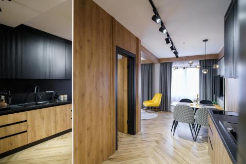 a kitchen and dining room with black cabinets and a table at Podhalańskie Marzenie by Apart Concept Podhale in Kościelisko