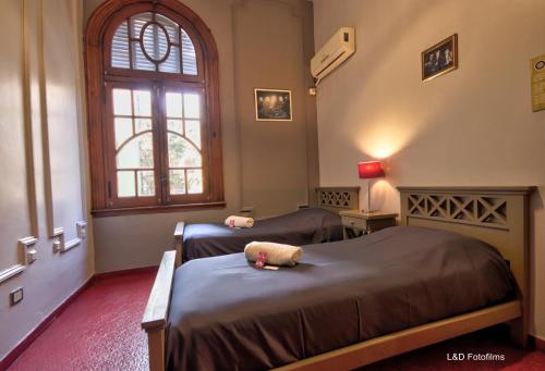 a room with two beds and a window at Play Hostel Arcos in Buenos Aires