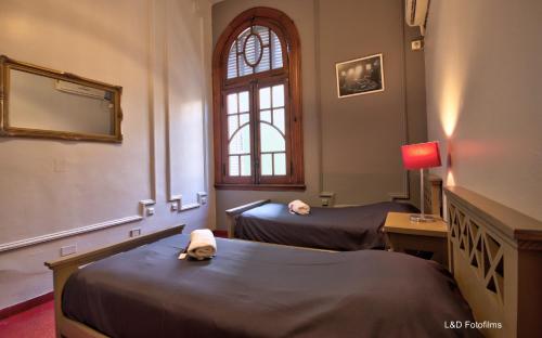 a room with two beds and a window at Play Hostel Arcos in Buenos Aires