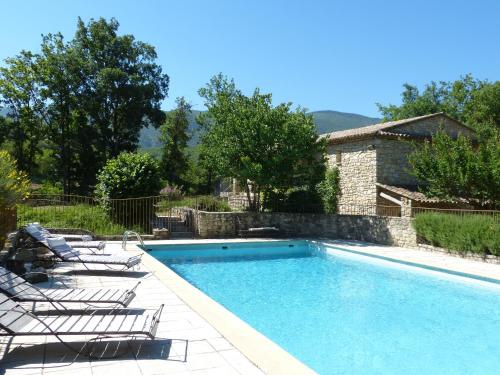 a swimming pool with chairs and a house at Hôtel Lou Caleù restaurant le Rocher des Abeilles in Saint-Martin-de-Castillon