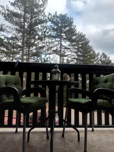 a table and chairs on a porch with trees at Simic Apartmani Tara in Kaludjerske Bare