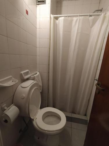 a bathroom with a toilet and a shower at Play Hostel Arcos in Buenos Aires