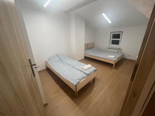 2 camas en una habitación pequeña con puerta en BELWEDER 12, en Warlubie