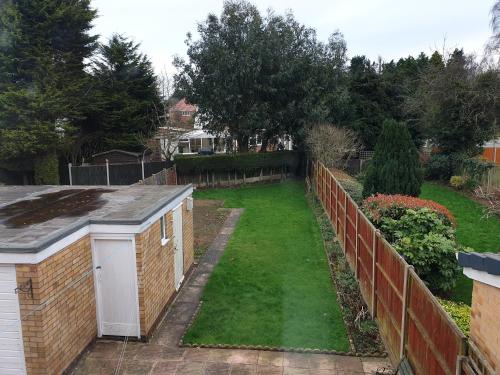 a backyard with a fence and a yard withgrass at Spencefield House in Leicester