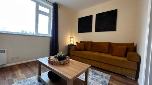 a living room with a couch and a table at Cozy 2 Bedroom Apartment close to Town Centre in Woking
