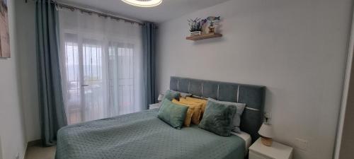 una camera da letto con letto, cuscini e finestra di Oceanfront Villa - Tenerife South a San Miguel de Abona