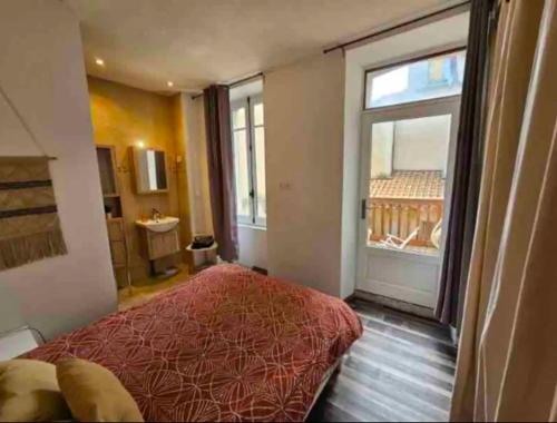 une chambre avec un grand lit et une grande fenêtre dans l'établissement Le 73 Bastide, à Carcassonne