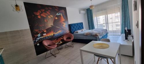 Habitación con 1 cama, 2 sillas y mesa. en MILENIJUM APARTMANIII, en Podgorica