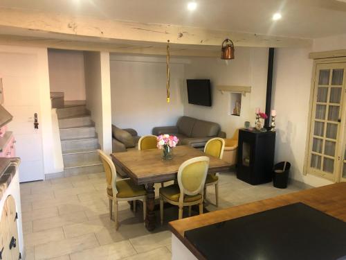 un salon avec une table, des chaises et un canapé dans l'établissement Le choupisson, à Estoublon