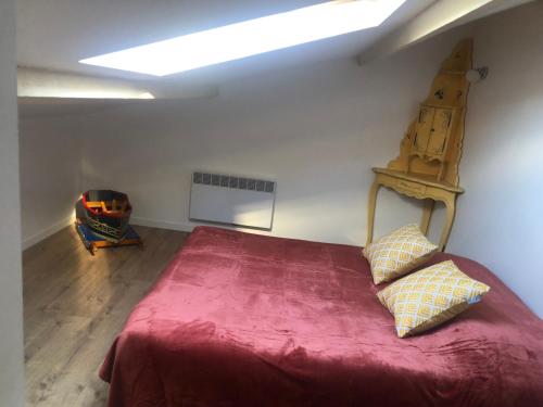 - une chambre avec un grand lit rouge et 2 oreillers dans l'établissement Le choupisson, à Estoublon