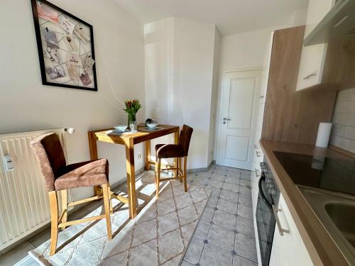 a small kitchen with a small table and chairs at Retreat am Teich in Altenburg