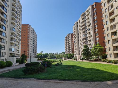 a grassy area between two tall apartment buildings at Departamento Santiago de Chile in Santiago