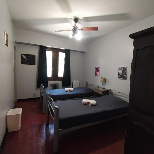 a room with three beds and a ceiling fan at Play Hostel Arcos in Buenos Aires