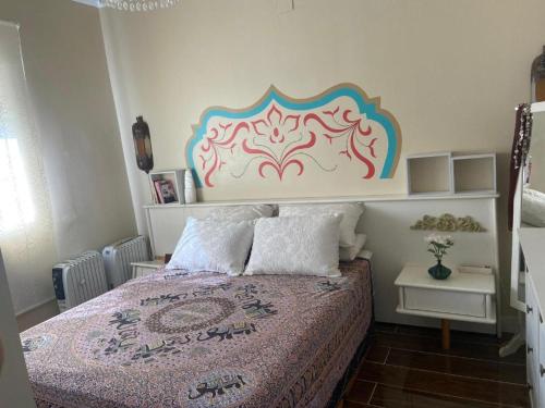1 dormitorio con 1 cama con cabecero colorido en Casa Cruz en Gelves