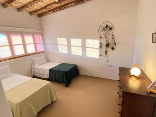 a room with two beds and a window at Complejo HUNUC in Calingasta