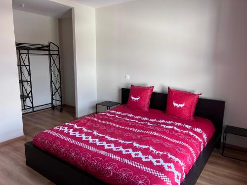 - un lit rouge avec des oreillers rouges dans l'établissement Maxime, à Colmar