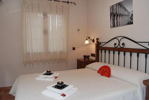 1 dormitorio con 2 camas con sábanas blancas y almohadas rojas en Casa Rural "Los Herrero" en Zarzuela del Monte