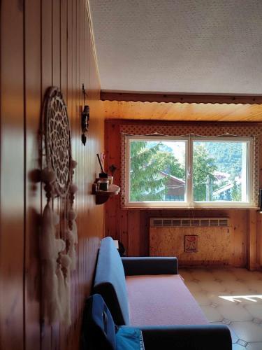 a living room with a couch and a window at La Finestrella Alpina in Piancavallo