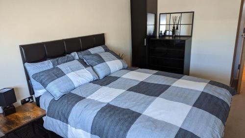 a bedroom with a bed with a checkered blanket at Excellent Leeds City Centre 1 Bedroom Apartment in Leeds