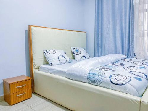 uma cama com cobertores e almofadas azuis e brancos em 3bedrooms Home in Musanze em Cyuve