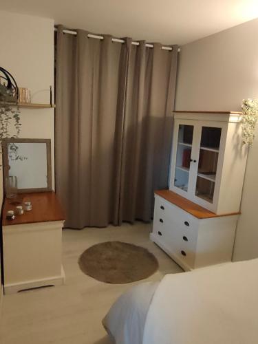 1 dormitorio con cama, tocador y espejo en Le petit Migault, en La Creche